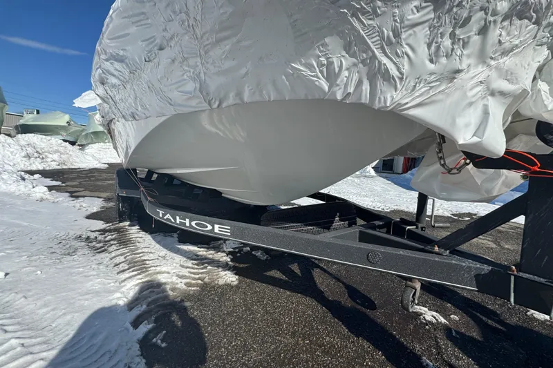Slide: The Image of Covered 2023 Tahoe 1950 boat on trailer in snowy outdoor setting. - 2