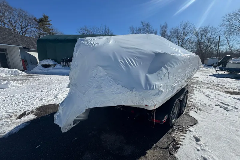 Slide: The Image of Covered Tahoe 1950 boat on trailer in snowy outdoor setting, 2023 model. - 6