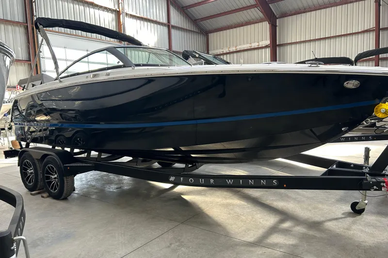 Slide: The Image of 2026 Four Winns H2 boat in a warehouse, displayed on a trailer. - 10