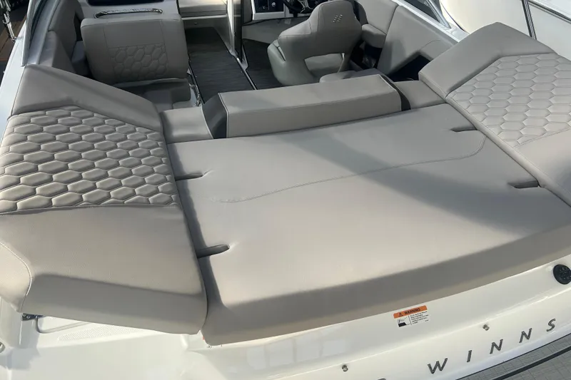 Slide: The Image of 2026 Four Winns H2 boat interior with gray cushioned seating and hexagonal pattern design. - 17