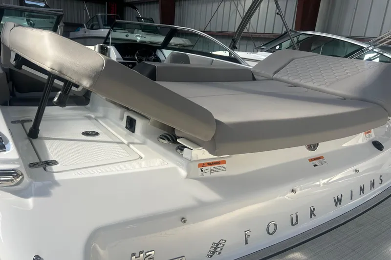 Slide: The Image of 2026 Four Winns H2 boat with adjustable seating and sleek design in a showroom. - 18