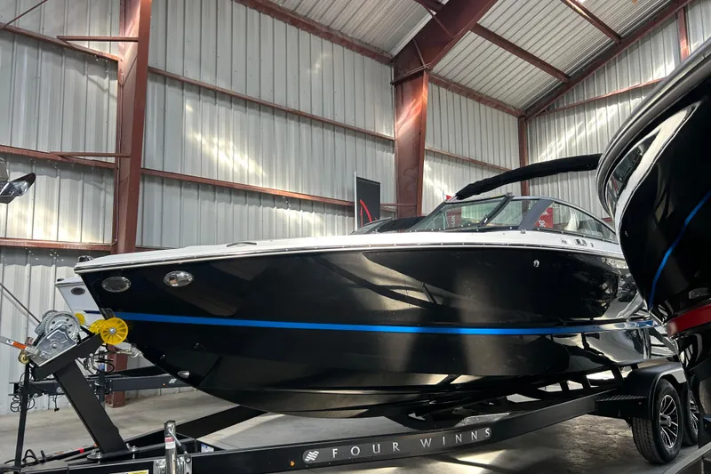 Slide: The Image of 2026 Four Winns H2 boat in a warehouse, showcasing sleek black design and modern features. - 9