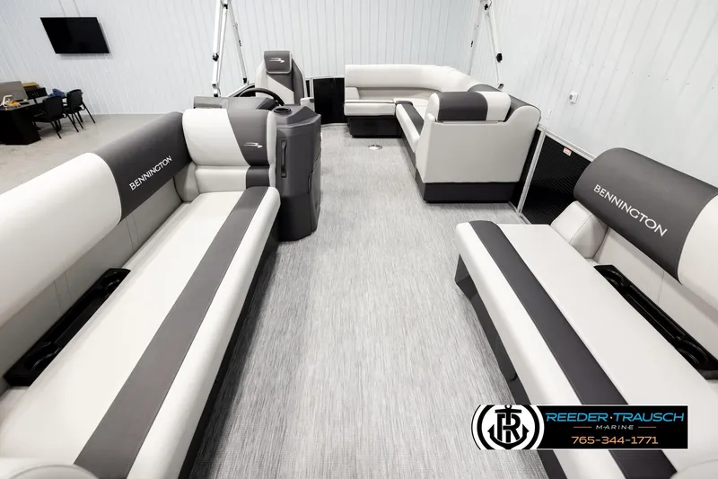 Slide: The Image of 2026 Bennington SLSF boat interior with gray and white seating, displayed at Reeder-Trausch Marine. - 13