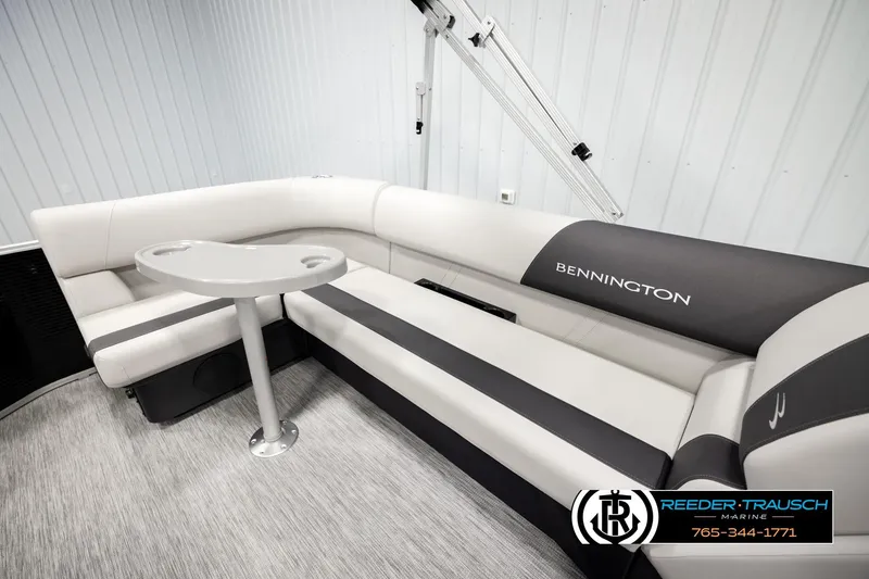 Slide: The Image of 2026 Bennington SLSF boat interior with sleek seating and table, showcased by Reeder-Trausch Marine. - 23