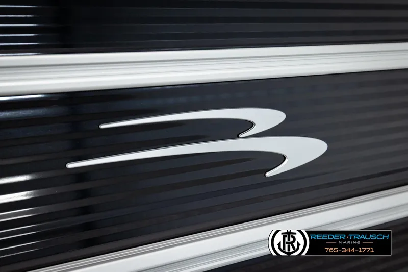 Slide: The Image of 2026 Bennington SLSF boat logo on sleek black surface, Reeder-Trausch Marine branding. - 47