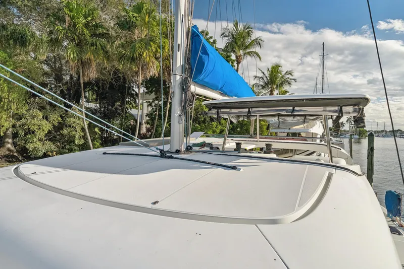 Slide: The Image of 2020 Lagoon 42 catamaran docked, featuring a sleek design and blue sail cover. - 2