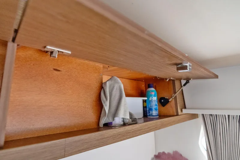 Slide: The Image of Open wooden cabinet in Lagoon 42 yacht, storing cleaning supplies and cloth. - 23