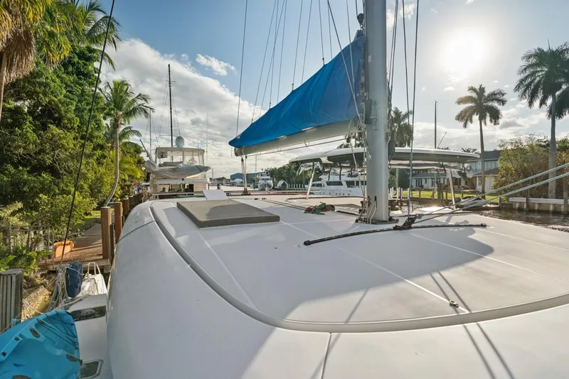 Slide: The Image of 2020 Lagoon 42 catamaran docked, surrounded by palm trees and clear skies. - 3