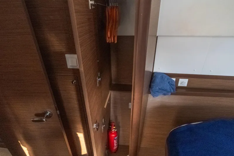 Slide: The Image of Interior of 2020 Lagoon 42 yacht with wooden closet and fire extinguisher. - 33