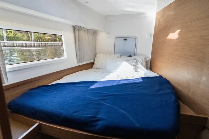 Slide: The Image of Cozy cabin interior of 2020 Lagoon 42 catamaran with bed and window view. - 36