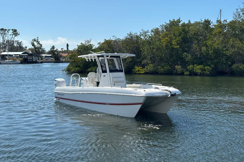The Image of 2026 World Cat 235 TE boat on calm water near lush greenery. - 0