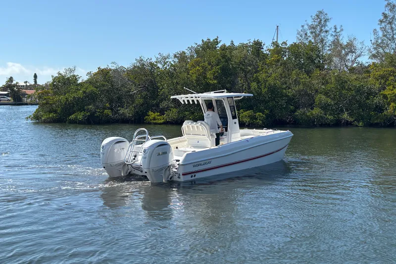Slide: The Image of 2026 World Cat 235 TE boat cruising on a calm river near lush greenery. - 2