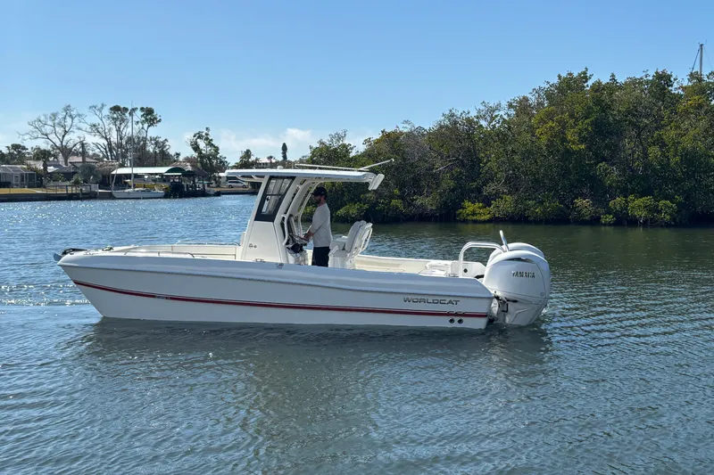 Slide: The Image of 2026 World Cat 235 TE boat cruising on a calm river with lush greenery. - 4