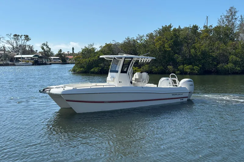 Slide: The Image of 2026 World Cat 235 TE boat cruising on a calm river with lush greenery. - 5