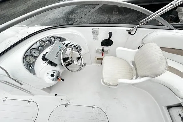 Slide: The Image of 2005 Starcraft Aurora 2210 OB boat cockpit with Garmin navigation and white seating. - 7