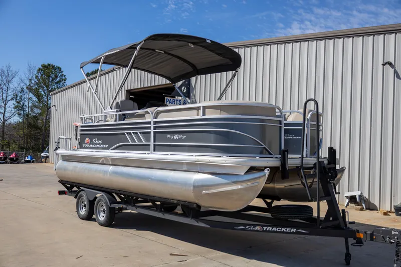 The Image of 2023 Sun Tracker Party Barge 20 DLX pontoon boat on trailer, parked outdoors. - 1