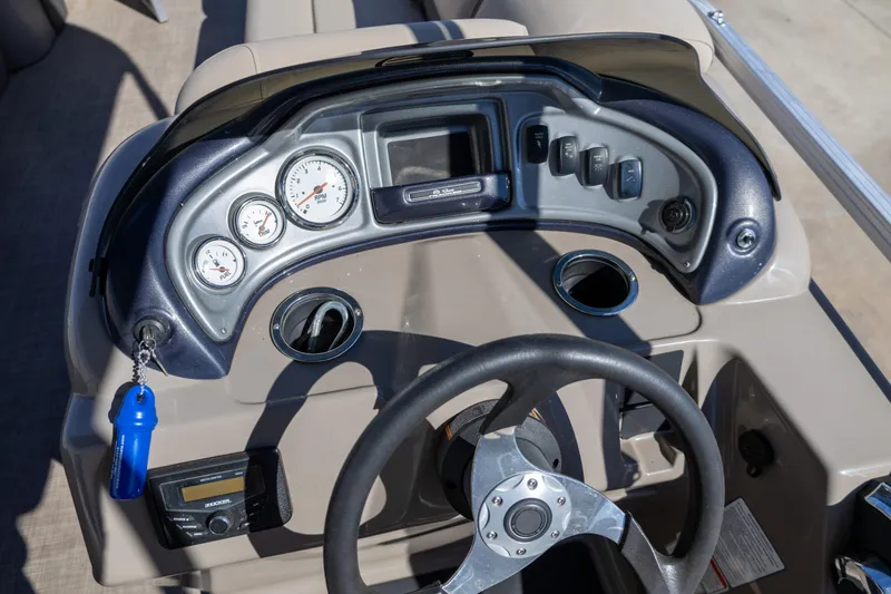 Slide: The Image of 2023 Sun Tracker Party Barge 20 DLX dashboard with steering wheel and gauges. - 10