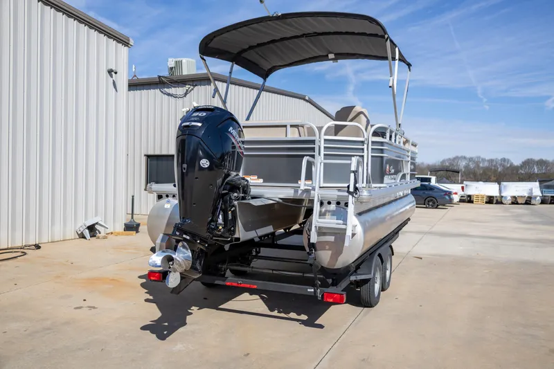 Slide: The Image of 2023 Sun Tracker Party Barge 20 DLX pontoon boat with outboard motor in a parking lot. - 4