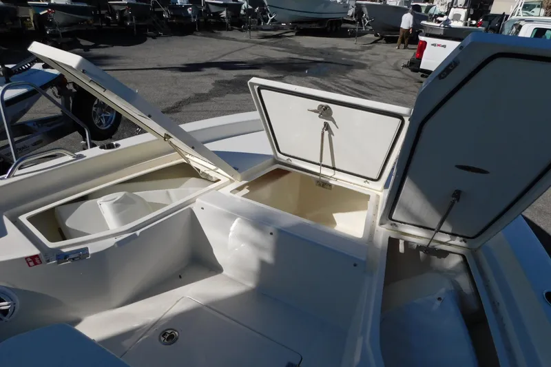 Slide: The Image of 2026 Pathfinder 2200 TRS boat with open storage compartments in a marina setting. - 19