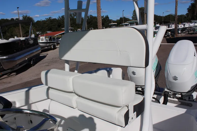 Slide: The Image of 2024 Clearwater 2300 CC boat interior with white seating and dual outboard motors. - 10