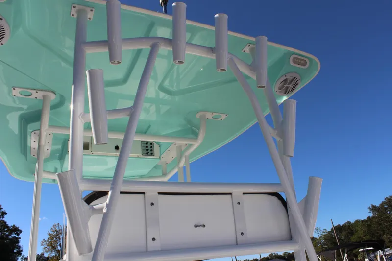 Slide: The Image of 2024 Clearwater 2300 CC boat with teal canopy and rod holders against blue sky. - 17