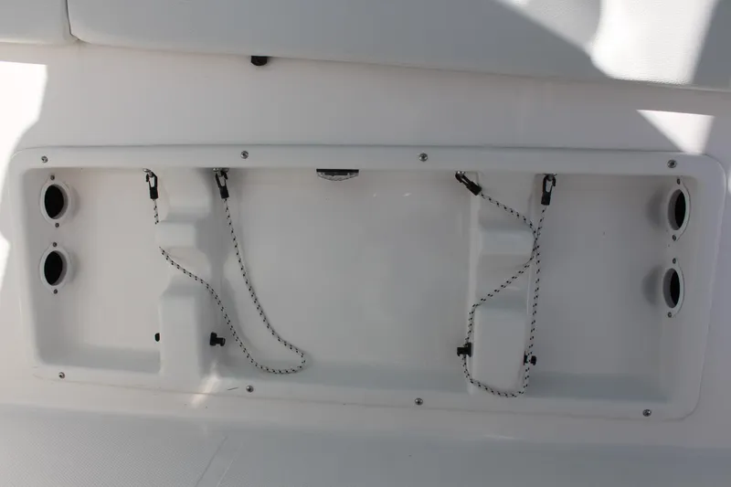 Slide: The Image of 2024 Clearwater 2300 CC boat storage compartment with bungee cords and cup holders. - 19