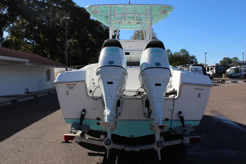 Slide: The Image of 2024 Clearwater 2300 CC boat with dual outboard engines, parked outdoors. - 4