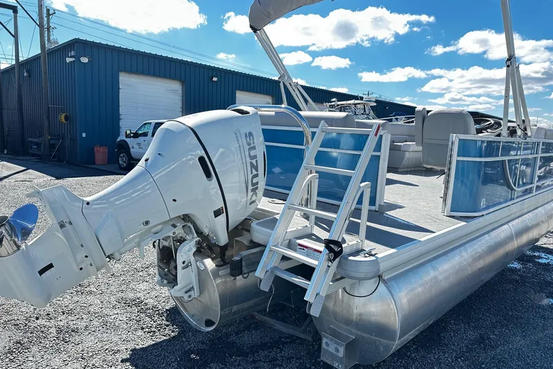 Slide: The Image of 2025 Godfrey Experience Cruise 2086CX pontoon boat with Suzuki outboard motor, docked outdoors. - 4