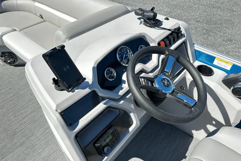 Slide: The Image of 2025 Godfrey Experience Cruise 2086CX boat dashboard with steering wheel and controls. - 6