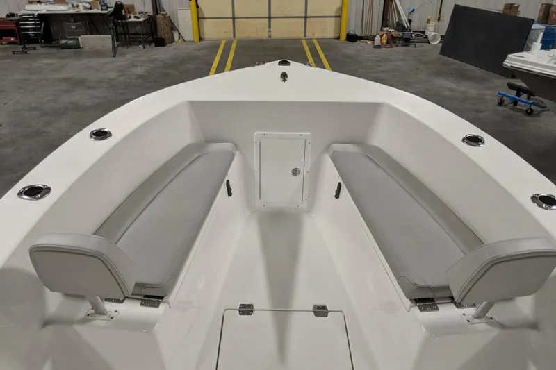 Slide: The Image of 2026 Bay Rider 21 Offshore boat interior with gray seating in a warehouse setting. - 10