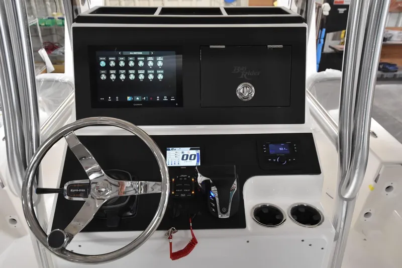 Slide: The Image of 2026 Bay Rider 21 Offshore boat dashboard with steering wheel and electronic controls. - 18