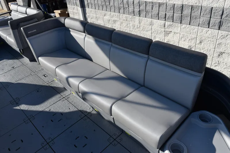 Slide: The Image of 2026 Sea-Doo Switch Cruise 21 boat seating with gray upholstery and cup holders. - 7