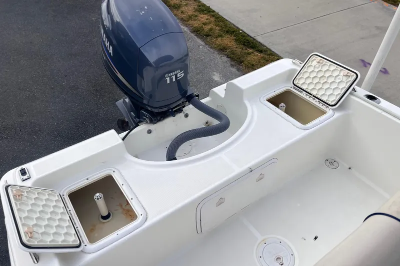 Slide: The Image of 2003 Cobia 184 Center Console boat with Yamaha 115 engine, open storage compartments. - 11