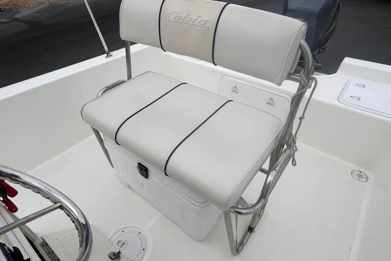 Slide: The Image of 2003 Cobia 184 Center Console boat seat with white cushioned backrest and storage. - 13