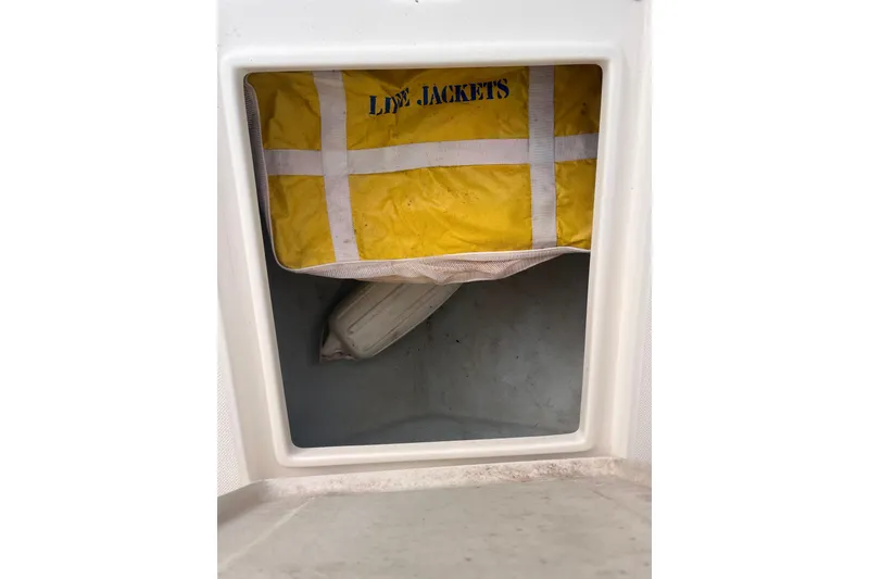 Slide: The Image of Storage compartment with life jackets on a 2003 Cobia 184 Center Console boat. - 20