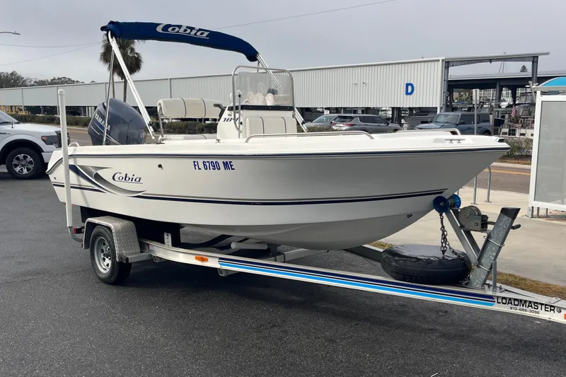 Slide: The Image of 2003 Cobia 184 Center Console boat on trailer, parked outdoors. - 4
