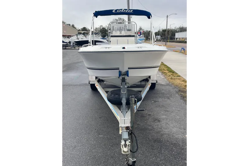 Slide: The Image of 2003 Cobia 184 Center Console boat on trailer, parked on a street. - 5