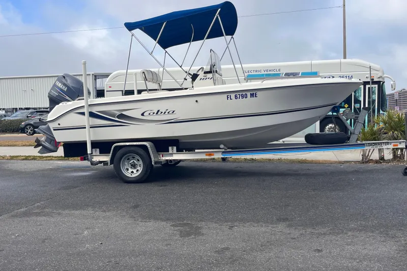 Slide: The Image of 2003 Cobia 184 Center Console boat on trailer with blue canopy and Yamaha motor. - 7