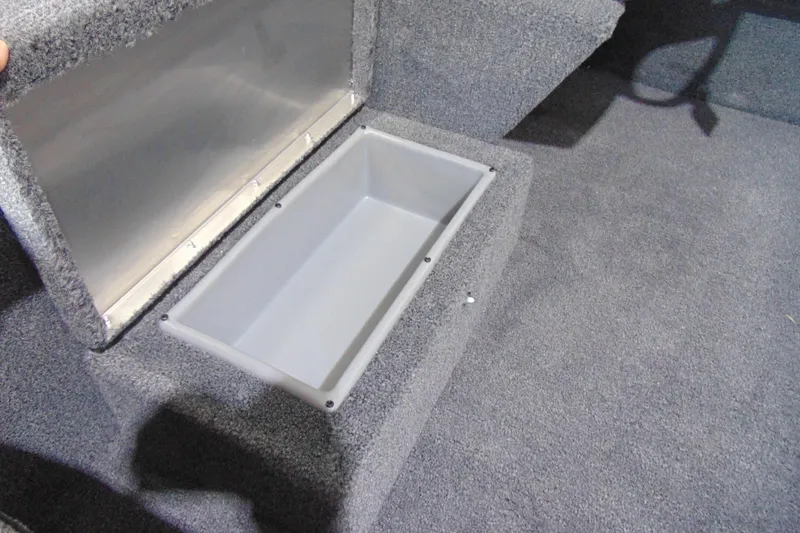 Slide: The Image of 2026 Crestliner 1600 Storm boat storage compartment with open lid, carpeted interior. - 10