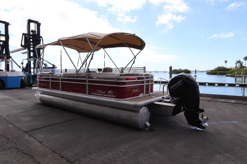 Slide: The Image of 2024 Sun Tracker Party Barge 22 DLX pontoon boat docked by the water. - 5