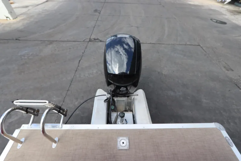 Slide: The Image of 2024 Sun Tracker Party Barge 22 DLX with outboard motor on a concrete surface. - 8