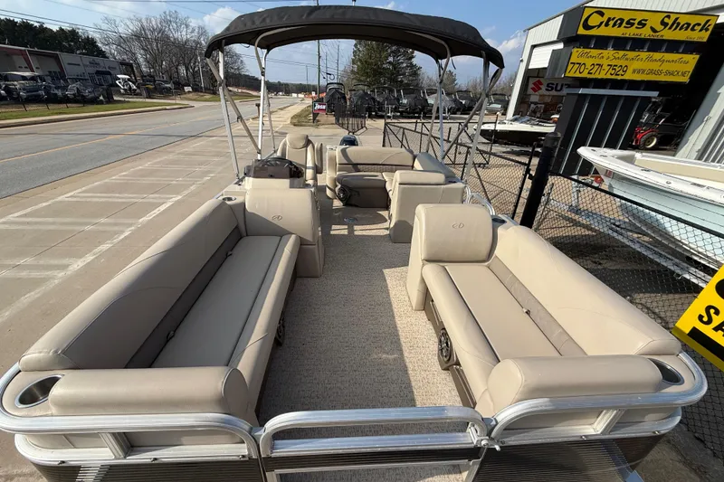 Slide: The Image of 2019 Avalon Venture 1880 CRB pontoon boat with beige seating and canopy, displayed outdoors. - 11