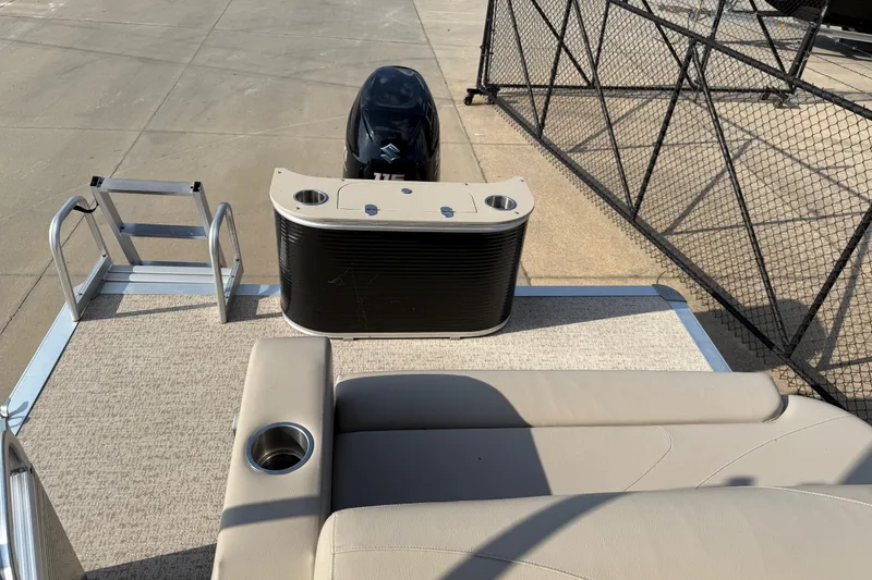 Slide: The Image of 2019 Avalon Venture 1880 CRB pontoon boat with seating and motor, docked by a fence. - 22