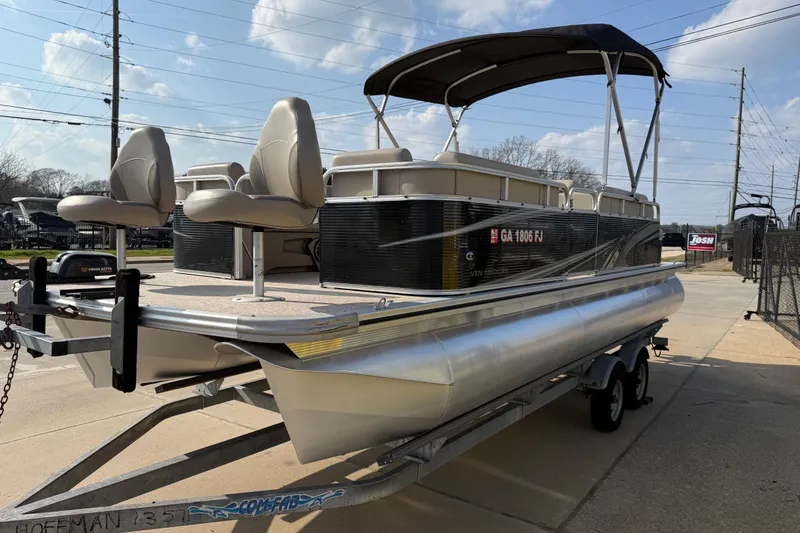 Slide: The Image of 2019 Avalon Venture 1880 CRB pontoon boat on trailer, featuring dual seats and canopy. - 5