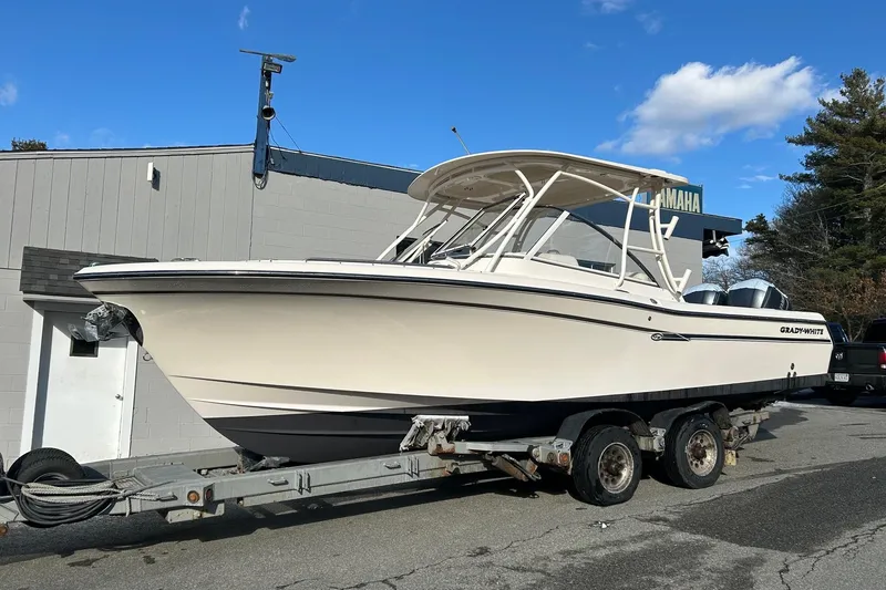 Slide: The Image of 2017 Grady-White Freedom 285 boat on trailer, parked outdoors under blue sky. - 2