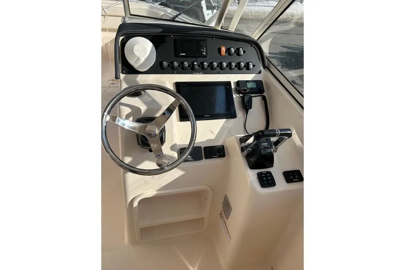 Slide: The Image of 2017 Grady-White Freedom 285 boat dashboard with steering wheel and control panel. - 4