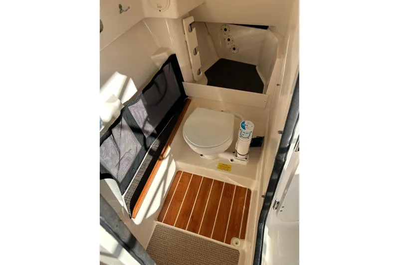 Slide: The Image of 2017 Grady-White Freedom 285 boat interior with toilet and wooden flooring. - 7