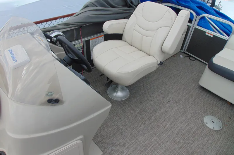Slide: The Image of 2019 Godfrey SW 180C boat interior with beige captain's chair and steering console. - 11