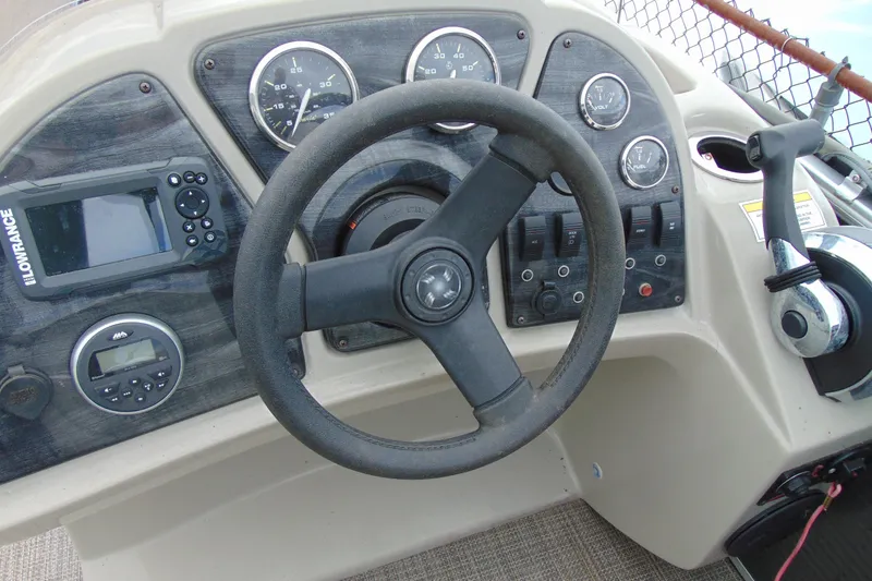 Slide: The Image of 2019 Godfrey SW 180C boat dashboard with steering wheel, gauges, and controls. - 16
