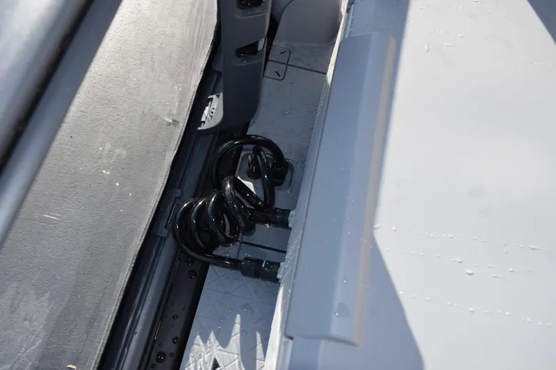 Slide: The Image of Coiled hose on 2026 Sea-Doo Switch Fish 21 deck, showcasing storage feature. - 12